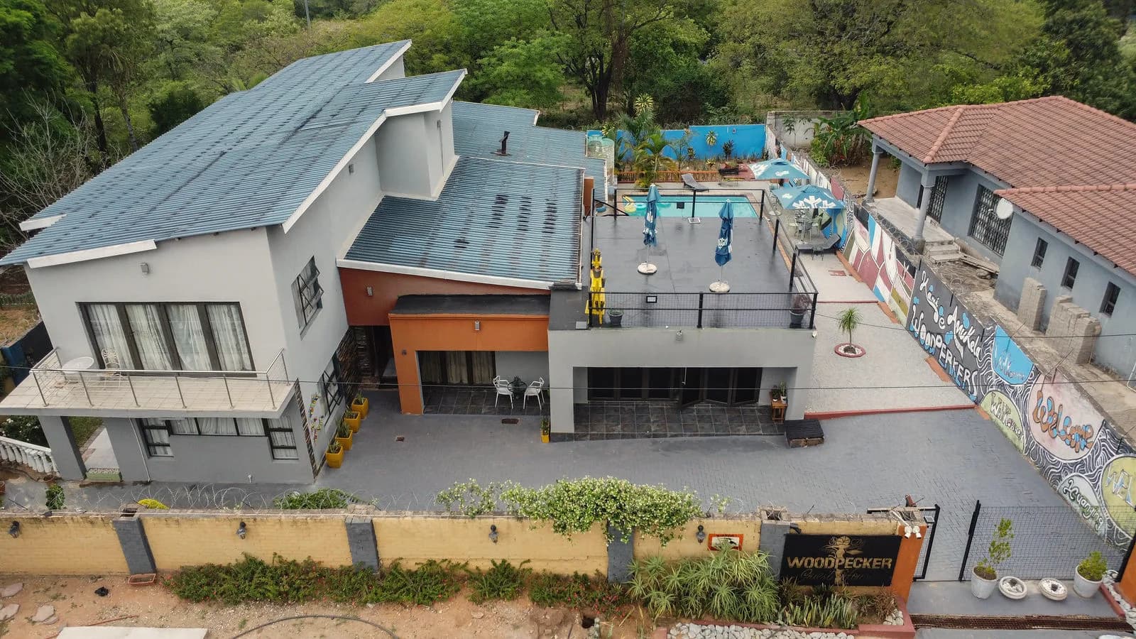The front of the guesthouse: the entrance and its sign, with the pool deck above